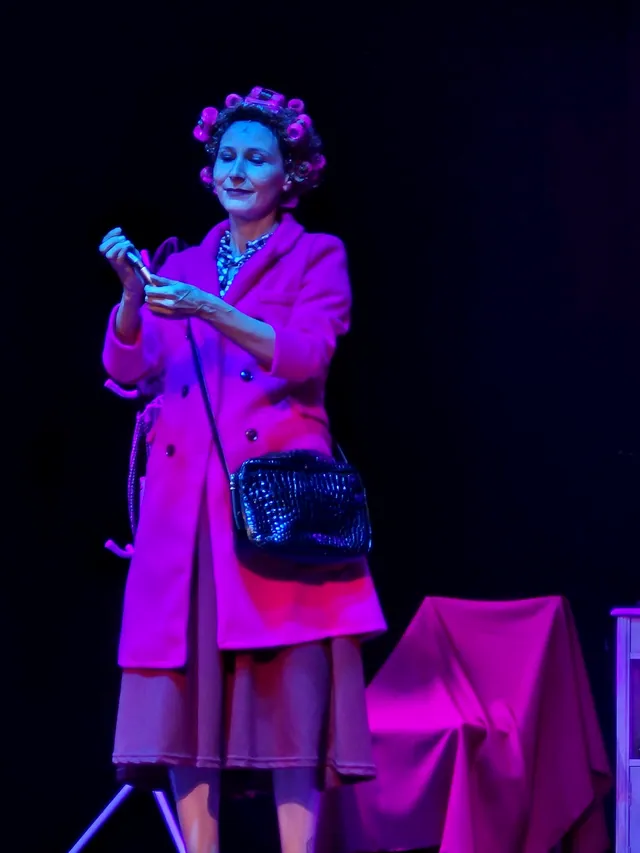 Margarita con el abrigo rosa y el micrófono