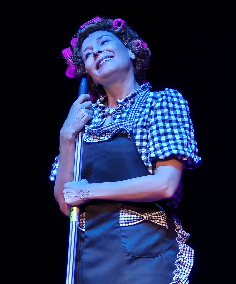 Primer plano de Margarita riendo, apoyada en la fregona
