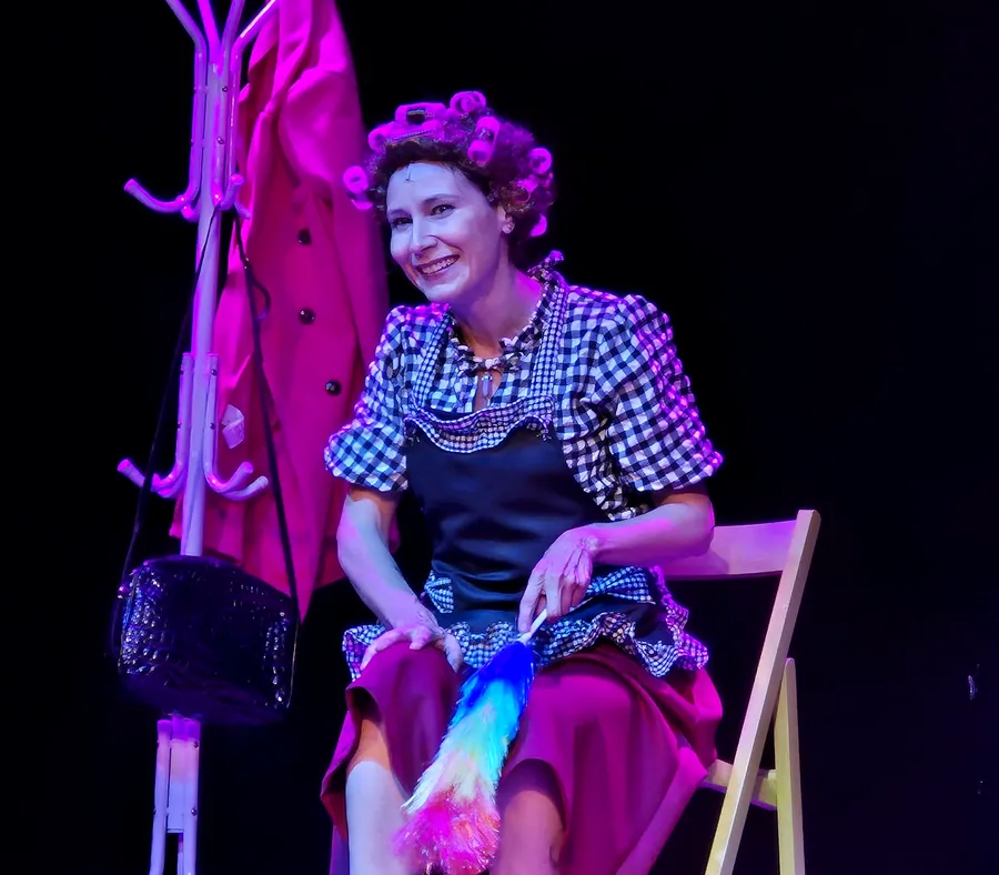 Silvia Schiavoni sentada en escena, con el plumero en la mano
